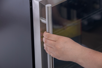 KBS Glastürkühlschrank 154 GU Nahaufnahme einer Hand am Edelstahlgriff der Glastür, geöffnete Tür, für professionelle Nutzung.