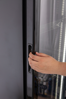 KBS Glastürkühlschrank 327 G Slim, Nahaufnahme einer Hand am Griff zum Öffnen der Glastür, schwarzes Gehäuse. KBS Glastürkühlschrank 327 G Slim, Nahaufnahme einer Hand am Griff zum Öffnen der Glastür, schwarzes Gehäuse.