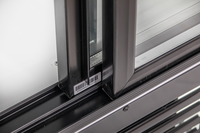 KBS Glastürkühlschrank 1250 GDU, Detailansicht der unteren Schiebetürführung mit Barcodeaufkleber, schwarzer Rahmen und Glasfront.